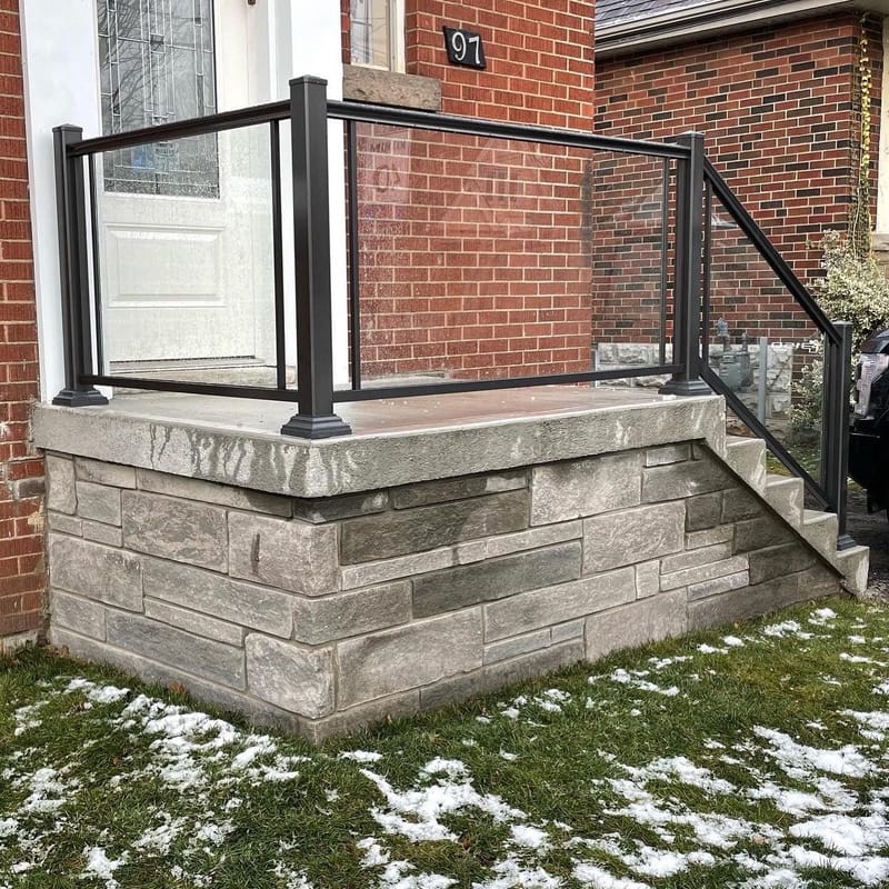 Stone porch with glass panel railing