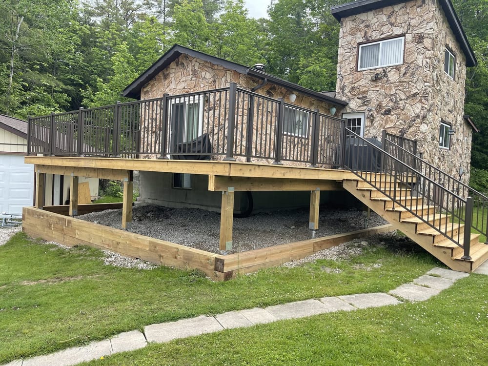 Raised cedar deck with bronze railing on stone cottage