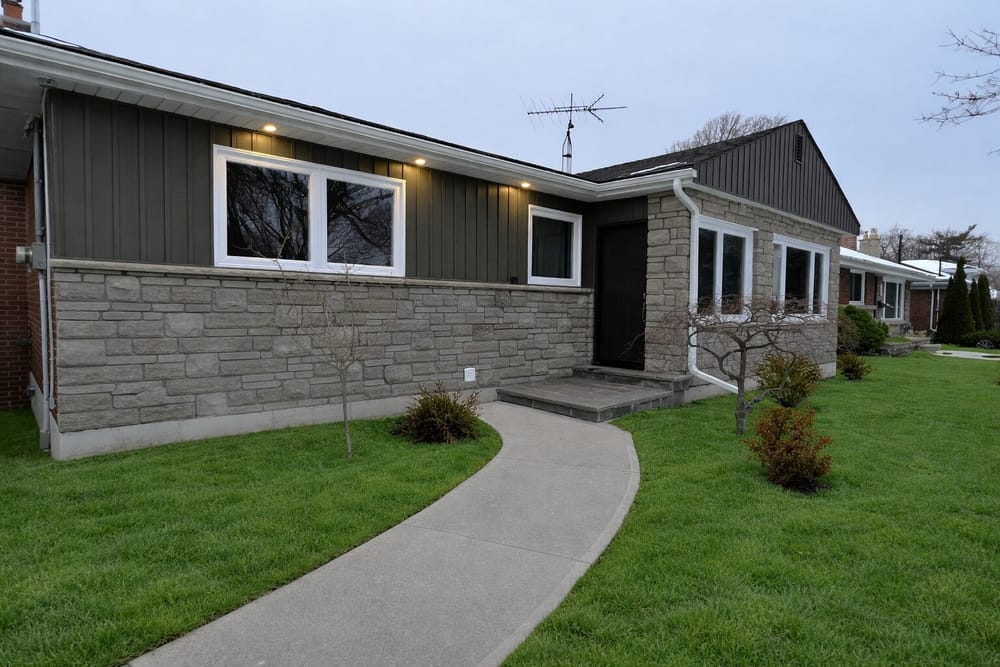 Stone and board-and-batten exterior renovation at dusk