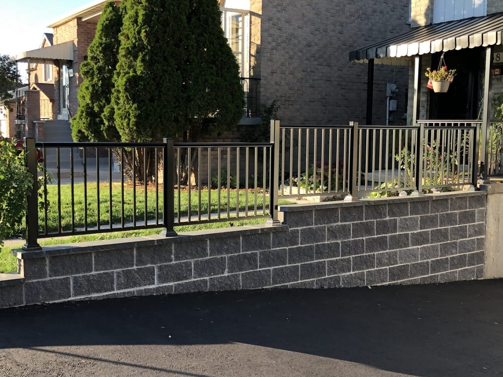 Block retaining wall with metal railing