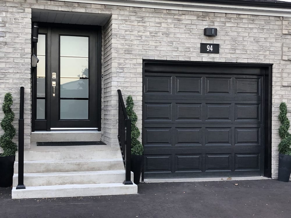 Modern front entry with black door and garage