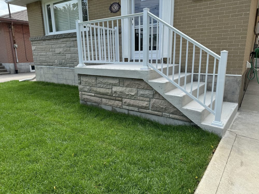 Stone porch and stairs with white aluminum railing
