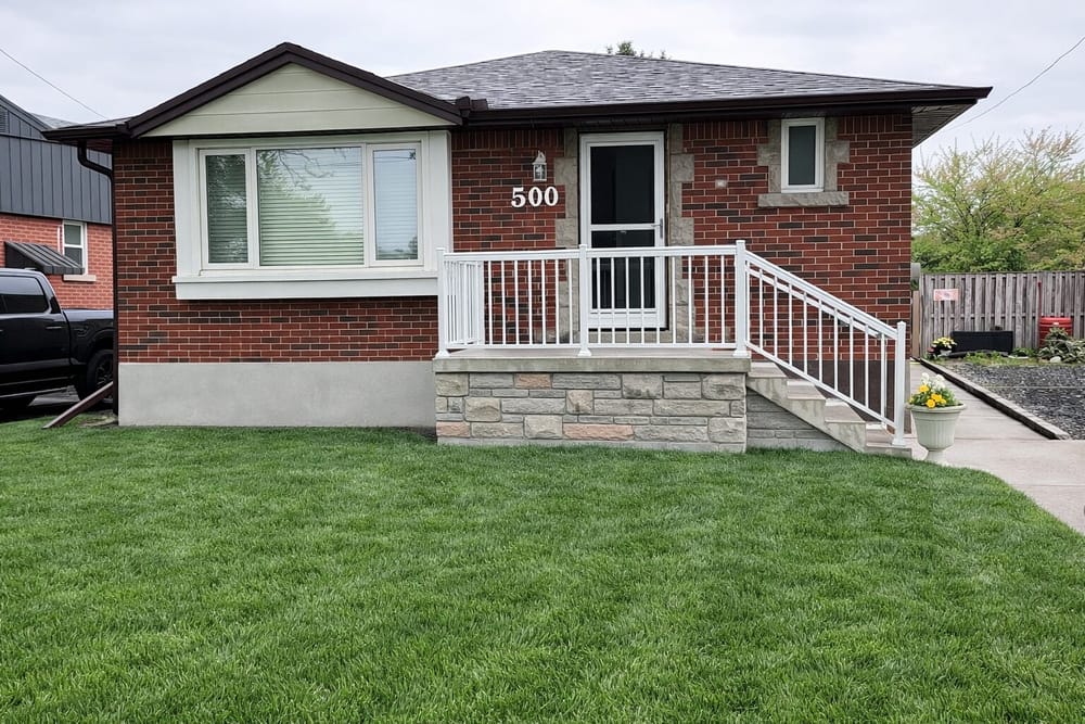 Brick bungalow with stone porch and white railing