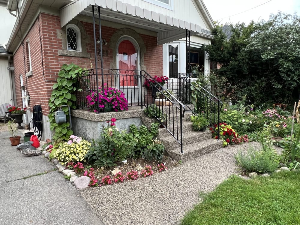 Exposed aggregate steps with iron railing and flower garden