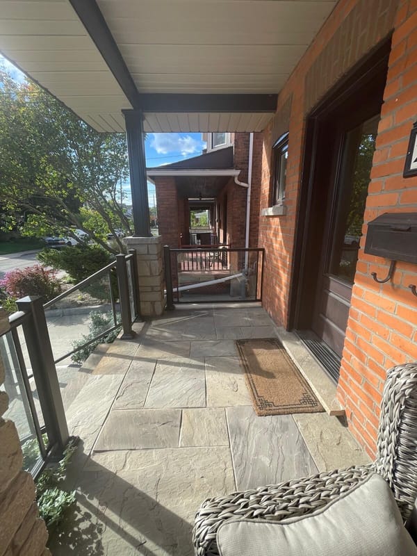 Covered flagstone porch with glass and bronze railing