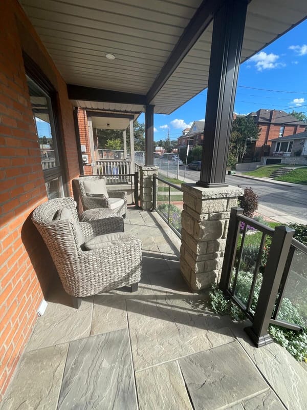 Covered porch with wicker chairs and stone columns