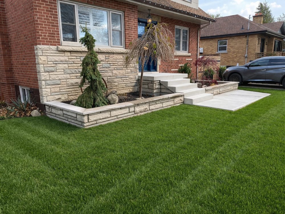Stone retaining wall with concrete steps and walkway