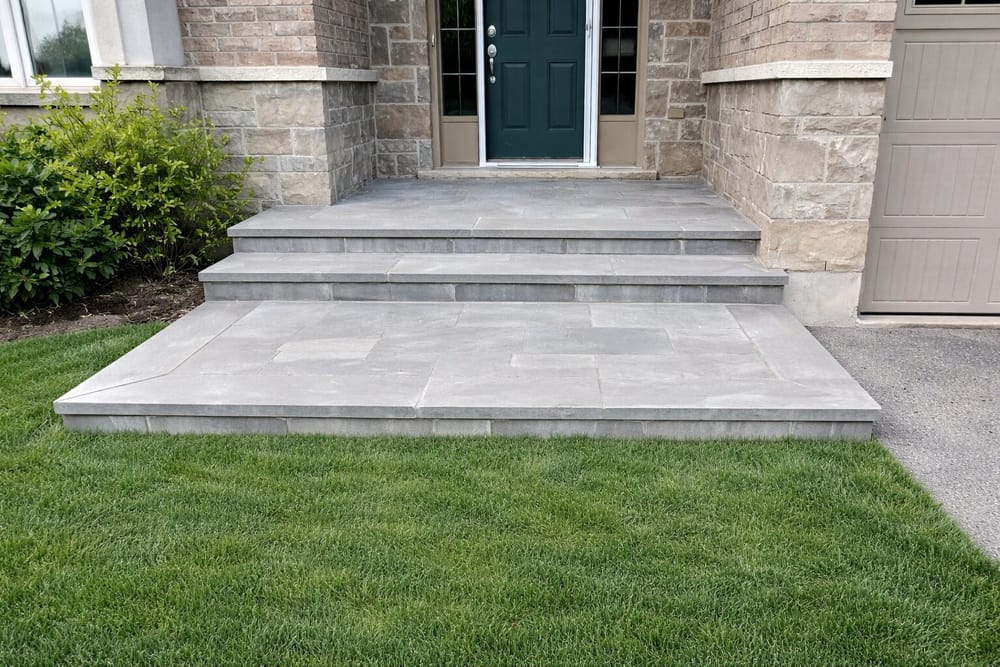 Clean gray stone steps with teal front door